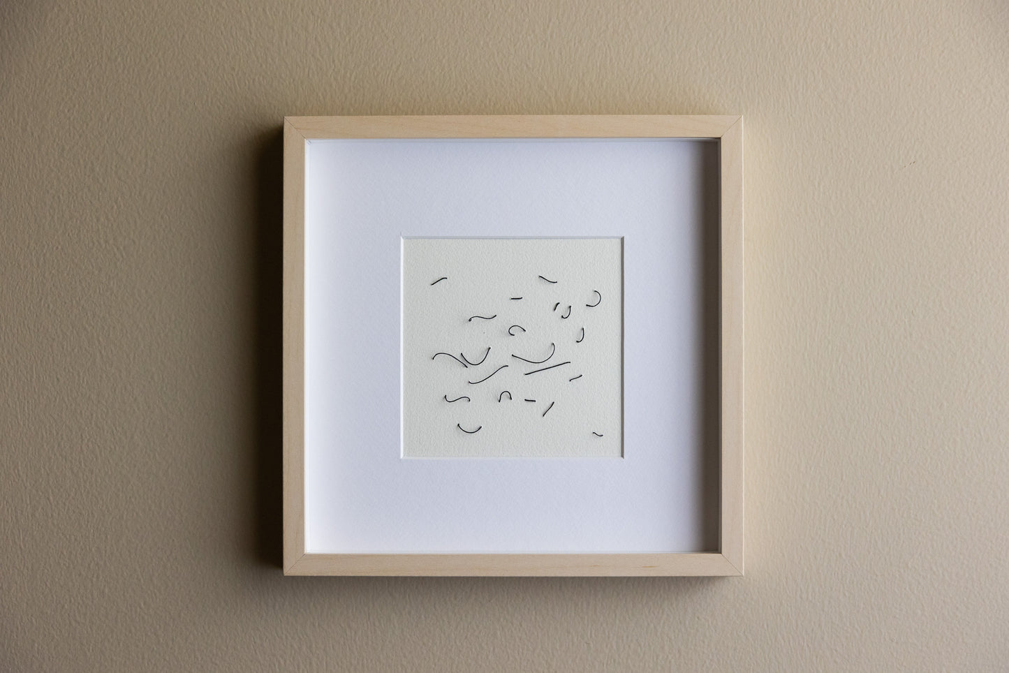 Framed abstract embroidery on paper, an original minimalist relief artwork representing black birds, changing with the light.