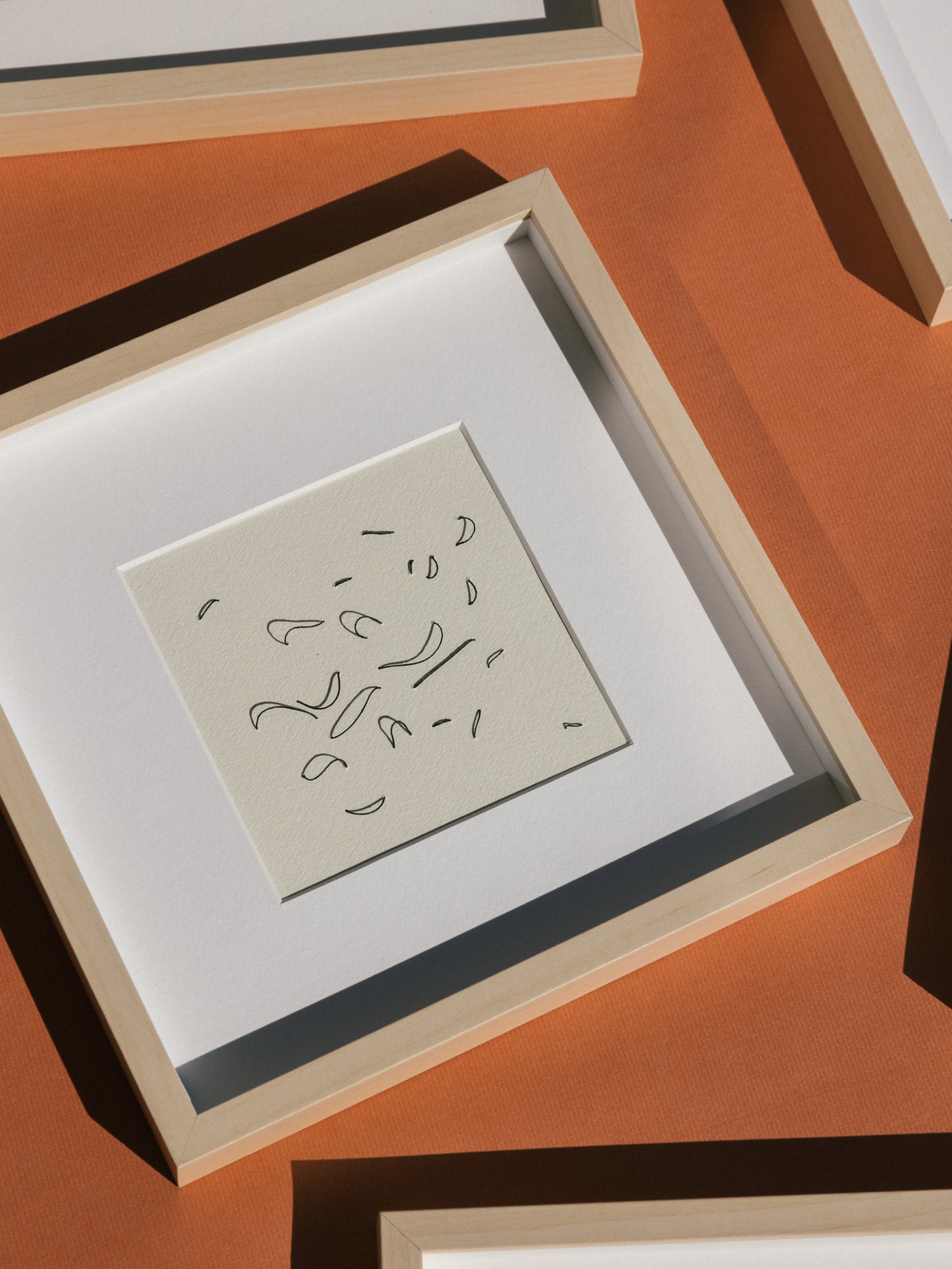 Framed abstract embroidery on paper, an original minimalist relief artwork representing black birds, changing with the light, on a background
