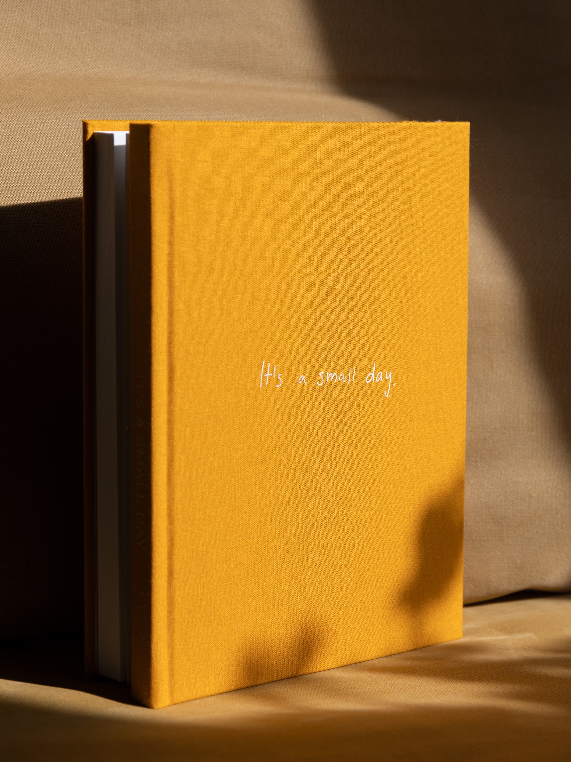 Artist's book titled 'It's a Small Day,' featuring 300 pages of photography and text in a unique two-in-one format, yellow cover