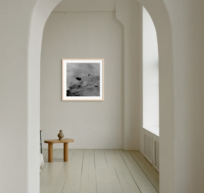 Black and white analog fine art photography print featuring a landscape with a lake and rocks in Norway, wall art in a handmade wooden frame. 