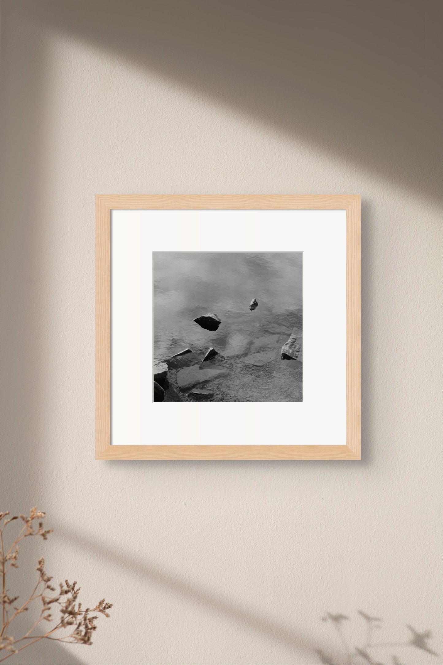 Black and white analog fine art photography print featuring a landscape with a lake and rocks in Norway, wall art in a handmade wooden frame. 