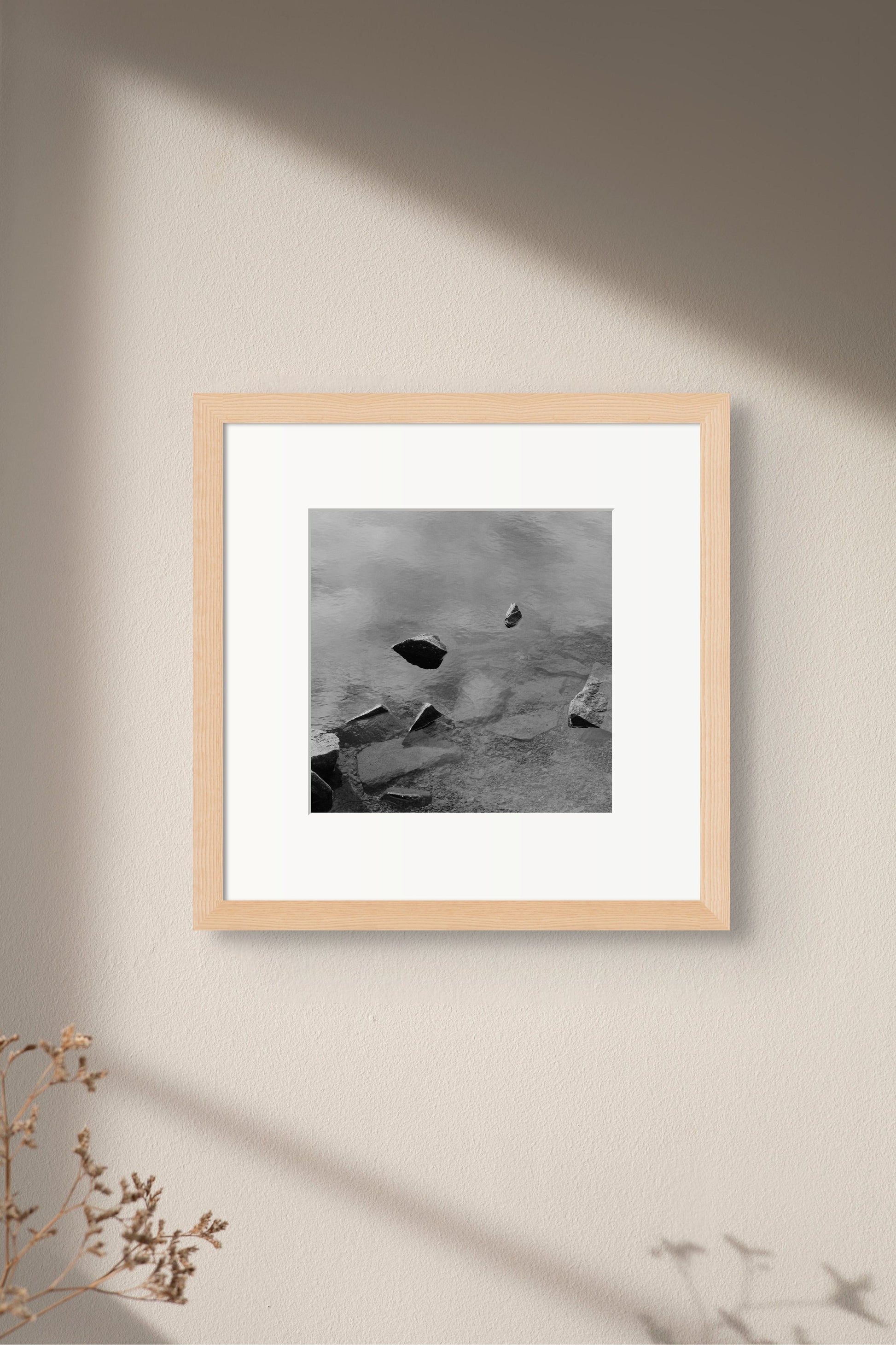 Black and white analog fine art photography print featuring a landscape with a lake and rocks in Norway, wall art in a handmade wooden frame. 
