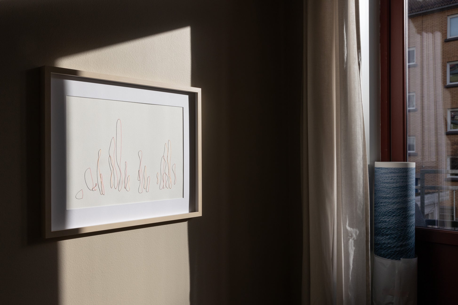 Original framed embroidery on paper,  showcasing intricate relief that changes with light, shown in the interior setup. 